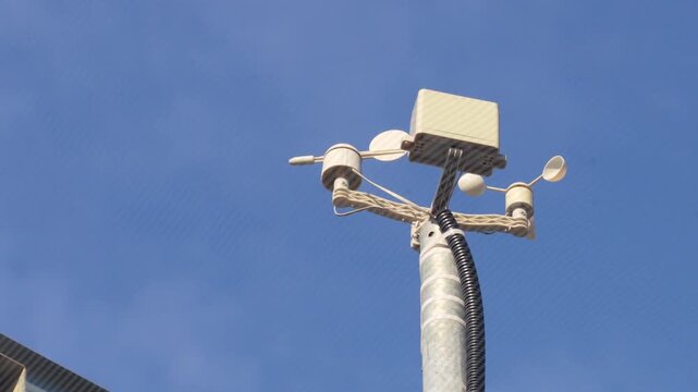 Aerial view of a weather station with wind sensors mounted on a pole against a clear blue sky in Faenza, Emilia-Romagna, Italy.