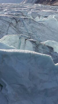 Closeup Of Glacial Formations Revealing Deep Blue Ice Cracks In Greenland. - aerial vertical shot