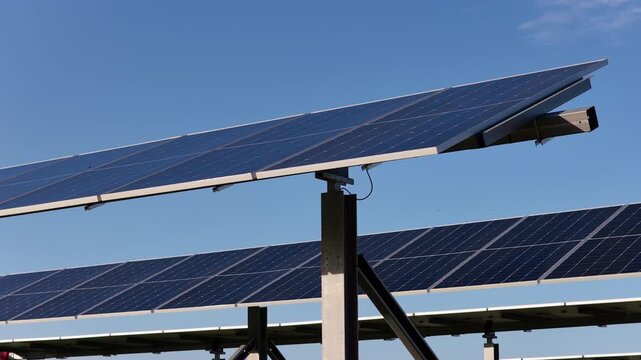 Aerial view of solar panels installed in a field under a clear blue sky in Terrasini, Sicily, Italy.