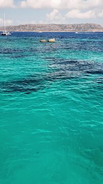Vertical  view of the turquoise bay with a rocky coastline with yachts and boats off the coast of Spargi Island in the La Maddalena archipelago, Sardinia, Italy