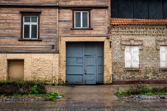   Weathered Wooden and Brick Facade With Blue Garage Doors