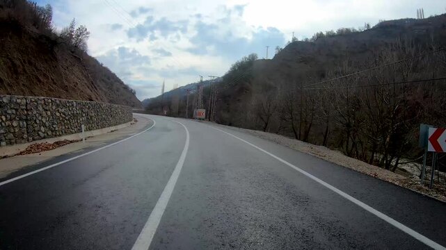 Time lapse driving POV in Bitlis, Turkey, on a winding mountain road along a river valley, dashcam view of an empty country road in eastern Anatolia