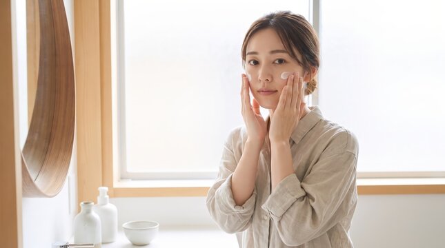 Both hands press against a Japanese woman&rsquo;s cheeks
