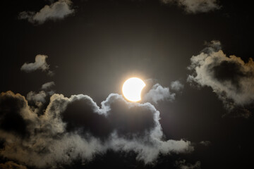 Partial solar eclipse captured as the Moon passes in front of the Sun, creating a striking crescent shape against the dark sky. An astronomical event photographed during daylight. © KjLOWRYPHOTOGRAPHY