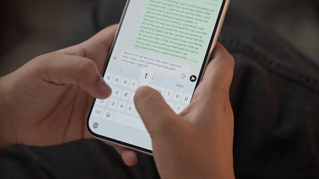 Woman's hand chatting and typing on a smartphone, macro closeup. Unrecognisable human typing a text message, tapping the touchscreen keyboard using the WhatsApp application, a social media.