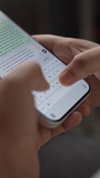Woman's hand chatting and typing on a smartphone, macro closeup. Unrecognisable human typing a text message, tapping the touchscreen keyboard using the WhatsApp application, a social media.
