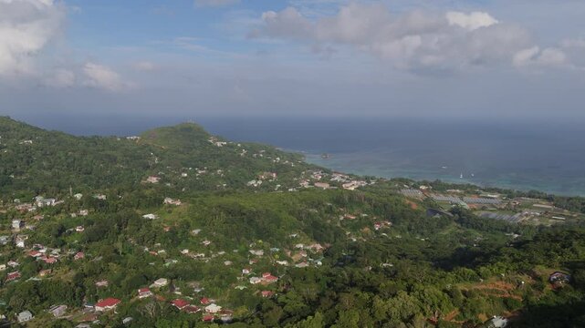 Aerial view of the lush green hills and coastal settlements of Mahe island in Seychelles.