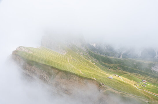 Misty mountain ridge with striped Alpine meadows in the dolomites