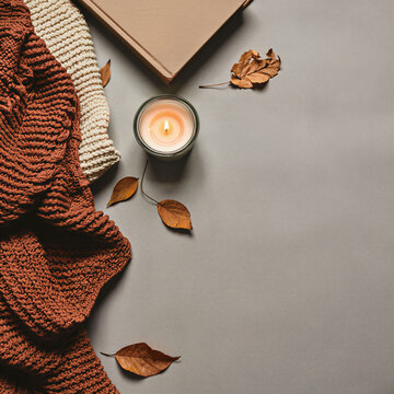 Cozy autumn flat lay with knit blanket candle and book