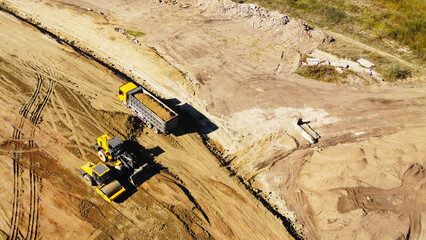 Aerial View of Dump Truck and Earthmoving Machinery at Construction Site © Andrey