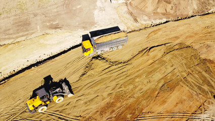 Aerial View of Dump Truck and Earthmoving Machinery at Construction Site © Andrey
