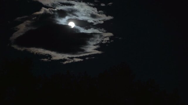 Time lapse of moon behind clouds
