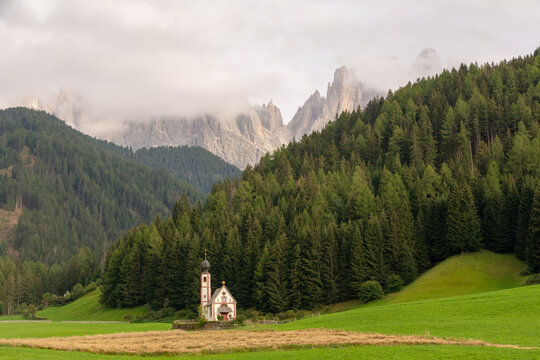 St. Johann church in Ranui with the Odle Dolomites and green meadows in Val di Funes, South Tyrol, Italy