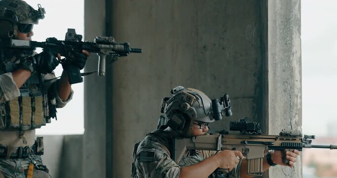 Military tactical operator moves between concrete pillars above city during urban operation
