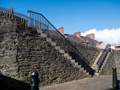 Historic stone steps and iron railings along Derry's City Walls in Northern Ireland, showcasing the preserved fortifications and distinctive architecture of the historic walled city.