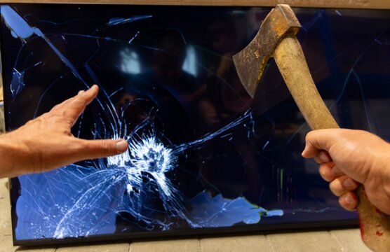 Person holding an axe in front of broken screen