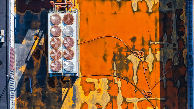 Aerial view of an industrial HVAC unit with multiple fans on a weathered orange and rust-colored flat roof in Southfield, Michigan, United States.
