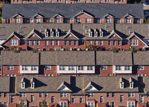 Aerial view of a dense residential complex with rows of red brick townhouses featuring gabled roofs, dormer windows, and symmetrical architectural details in Southfield, Michigan, United States.