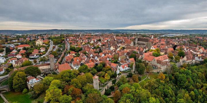 Aerial view of the historic medieval town of Rothenburg ob der Tauber with red-tiled rooftops, ancient defensive walls, and lush greenery in Rothenburg ob der Tauber, Bavaria, Germany.