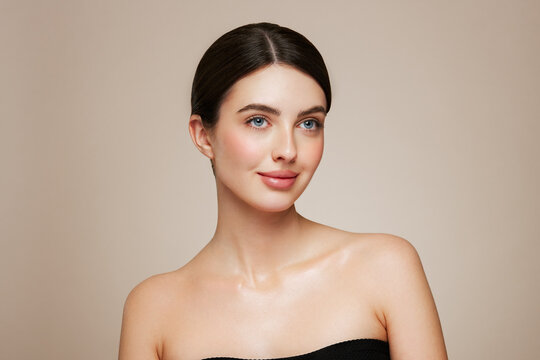 Portrait beautiful young woman with clean fresh skin. Model with healthy skin looks at an empty space, close up portrait. Cosmetology, beauty and spa