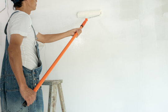 painter man, brush in hand for products to restore and paint the wall, indoor the building site of a house, wall during painting, renovation, painting, contractor, Architect, construction worker