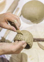 Hand carving decorative marks into a clay vessel © mitarart