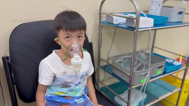 Asian Child using nebulizer mask equipment medication on clinic