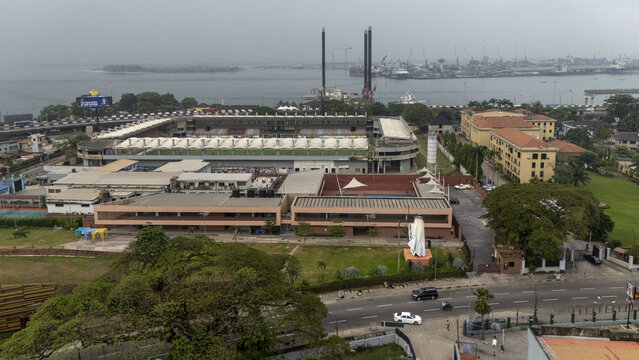 Aerial view of the Mobolaji Johnson Arena in Lagos Island, surrounded by urban infrastructure, lush trees, and nearby coastal waters in Lagos, Lagos, Nigeria.