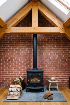Black Cast Iron Wood Stove on Slate Hearth Beneath Timber Truss