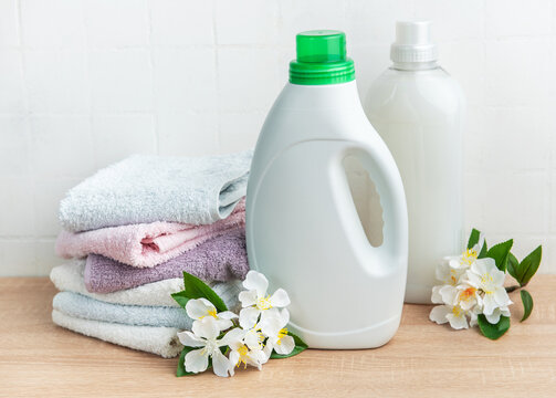 Detergent and fabric softener with fresh laundry towels and flowers