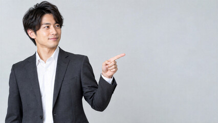 Fototapeta premium 選んだ方向を指差して自信のある微笑みを見せる日本人ビジネスマン