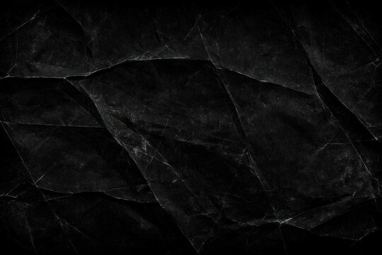 Dark crumpled paper texture with sharp creases and highlights