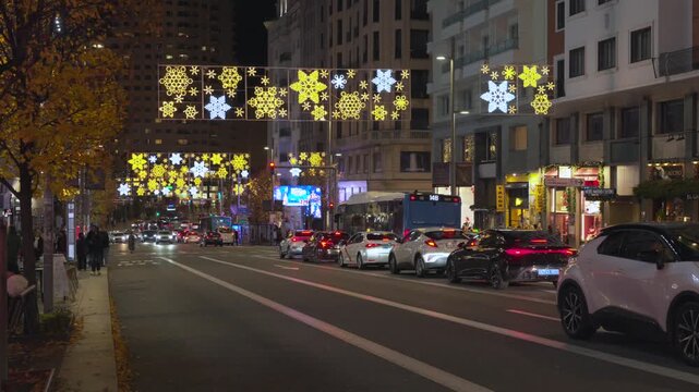Busy Madrid Street at Night with Festive Christmas Lights