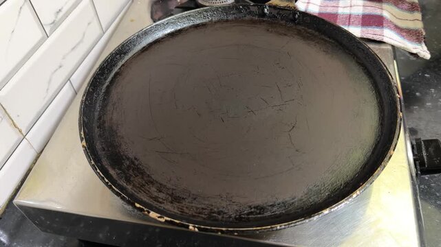 Greasing hot iron tawa pan before making dosa 4k video footage