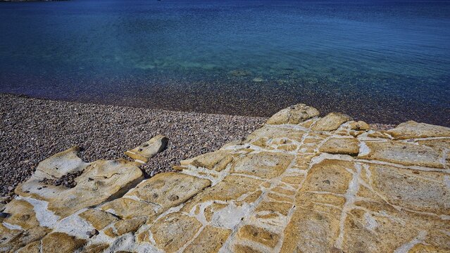 Rocky coast with pebbles and clear blue water under a blue sky, Lambi beach, pebble beach, Patmos, Dodecanese, Greek islands, Greece