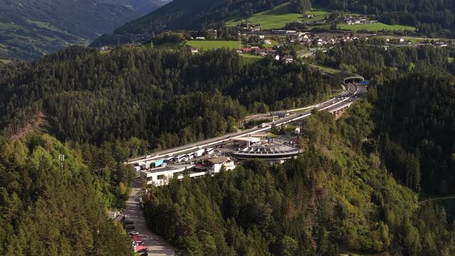 Drone aerial view of the Europa Bridge on the Brenner Autobahn near Innsbruck, Austria, spanning the Wipptal valley with alpine scenery and major transport infrastructure.