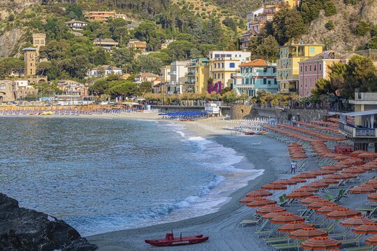 Sunbeds, parasols and red lifeboat, boulders on the beach di Fegina, Monterosso al Mare, Cinque Terre, Ligurian Coast, Liguria, Italy