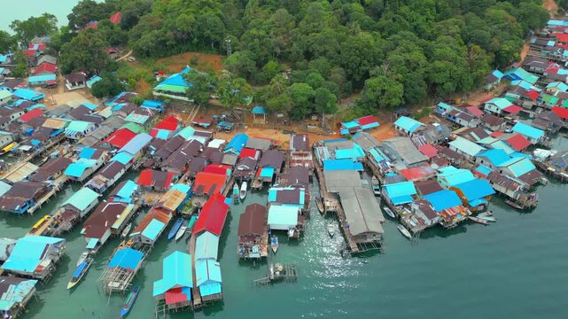 Aerial view of colorful stilt houses built over turquoise water on Batam Island, Batam, Riau Islands, Indonesia.