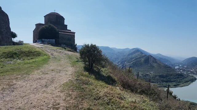 Video panorama from Jvari Monastery across Mtskheta, the Mtkvari and Aragvi river confluence, surrounding mountains and Georgian countryside under clear blue sky. Panoramic View from Jvari Monastery o