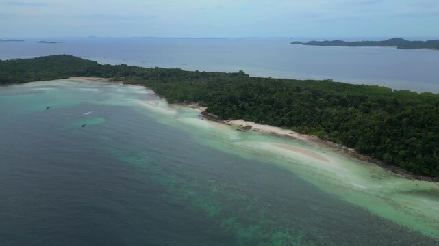 Aerial view of Batam Island featuring lush tropical forests, white sandy beaches, and clear turquoise waters in Batam, Riau Islands, Indonesia.