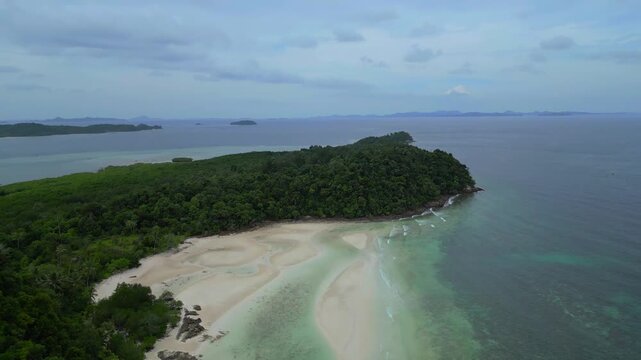 Aerial view of the lush green coastline and sandy beach of Batam Island in Batam, Riau Islands, Indonesia.