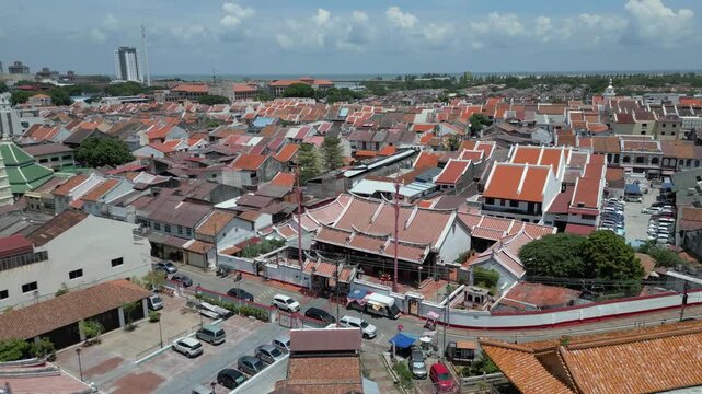 Aerial view of the historic Cheng Hoon Teng Temple with its traditional red-tiled roofs surrounded by urban streets and buildings in Malacca, Malacca, Malaysia.
