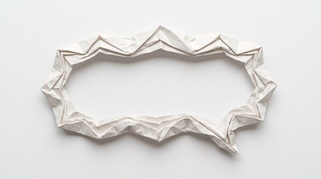 An empty speech bubble frame made of folded white paper with crisp artistic geometric creases isolated on a plain light grey studio background