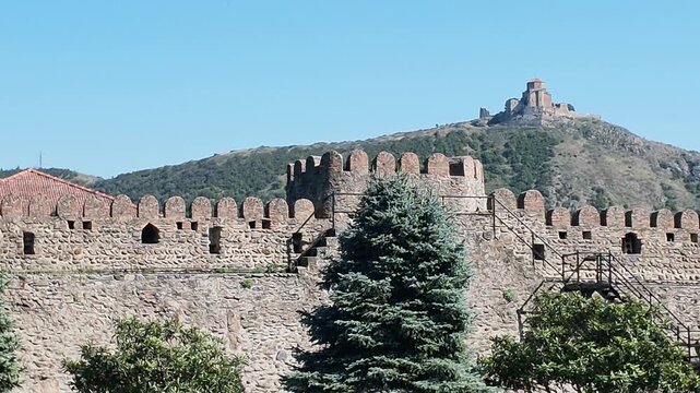 Jvari Monastery Above Historic Walls in Mtskheta.
Video view of Jvari Monastery on a hill above the historic stone walls of Svetitskhoveli Cathedral complex in Mtskheta, Georgia under a clear blue sky