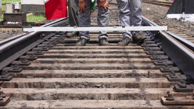 Workers measuring railway track gauge for rail alignment and maintenance