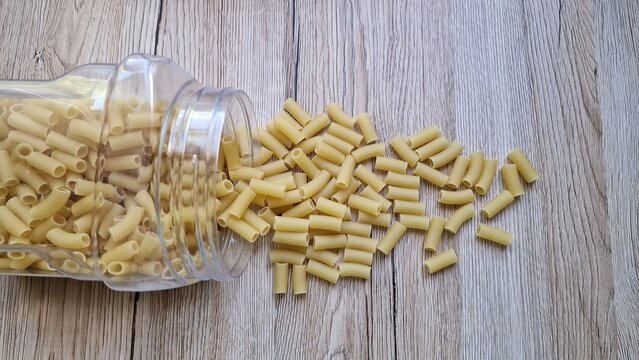 Pasta spilled from a jar onto the table