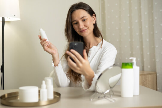Woman filming a beauty blog about skincare products and cosmetics during a home beauty routine