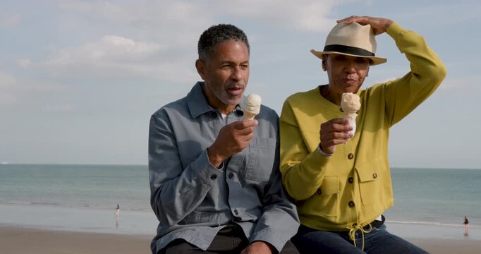 Senior Couple enjoying ice cream on the beach