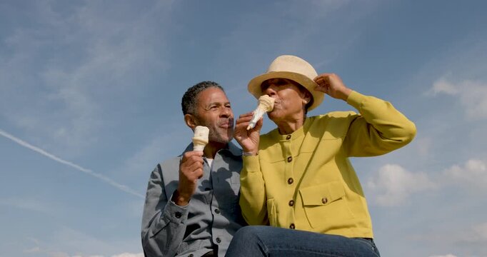 Senior Couple enjoying ice cream on the beach