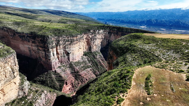 Aerial view of El Vergel canyon featuring deep rocky gorges with layered sedimentary rock formations and lush green plateau vegetation in Torotoro, Potosi Department, Bolivia.